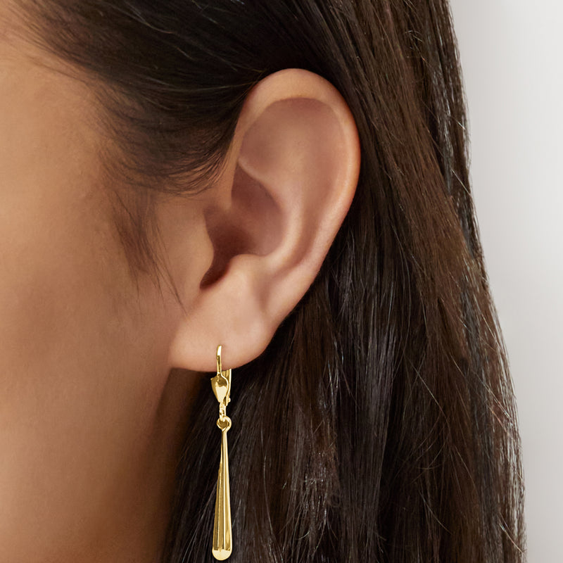 Yellow gold elongated teardrop dangle leverback earrings on ear
