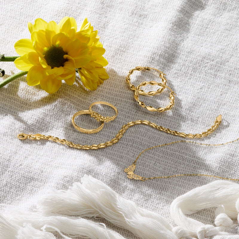 Gold wavy-link bracelet with scalloped wave links, coiled on fabric