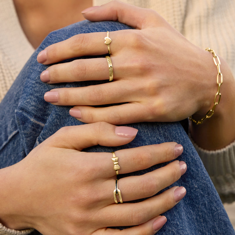 Heart ring in yellow gold worn on finger, heart face on slim band