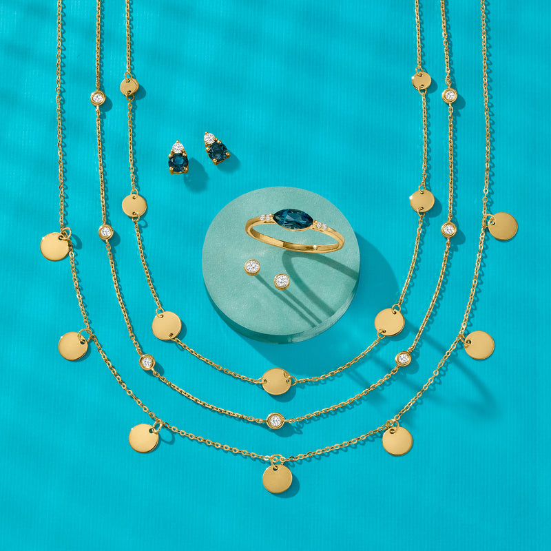 Gold ring with oval blue topaz centerpiece and round diamonds on each shoulder