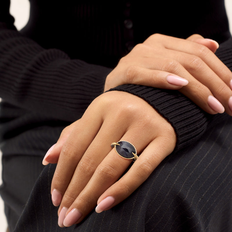 Oval sapphire ring on hand in 18kt gold over sterling with dark blue stone
