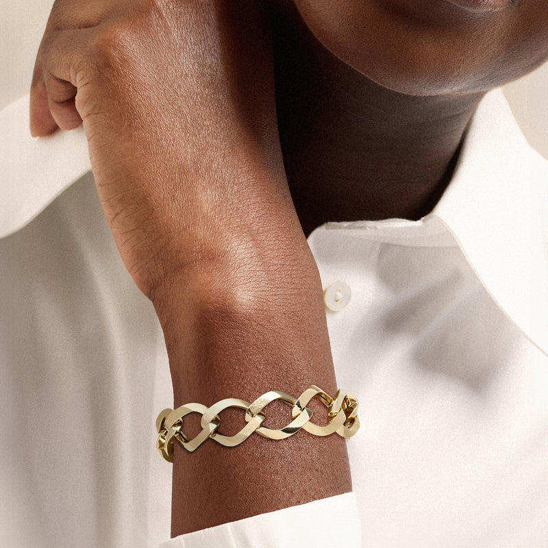 Yellow gold oval-link bracelet on wrist, secure clasp detail