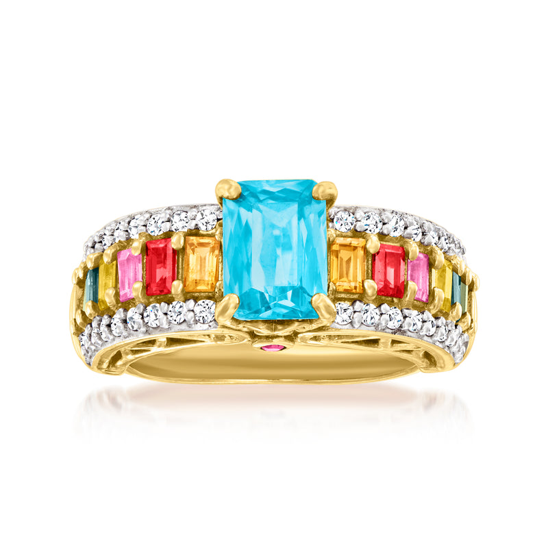 Gold-tone multi-gemstone ring with blue cushion center stone and clear white side accents
