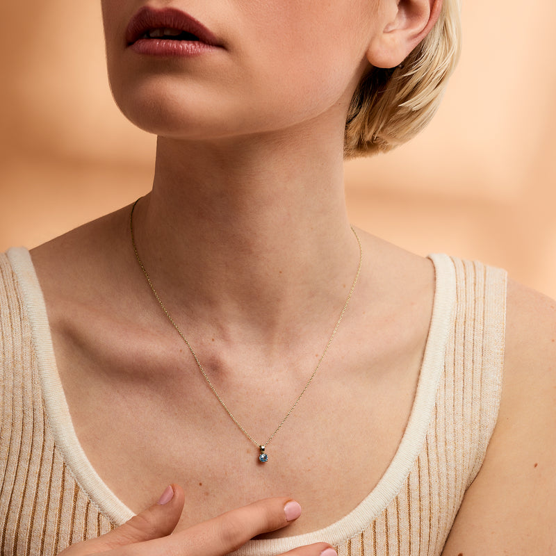 14kt yellow gold pendant necklace with tiny blue gemstone, prong-set