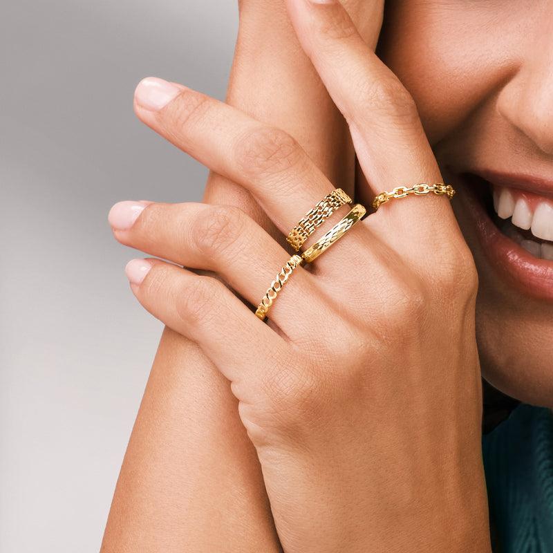 Yellow gold panther-link ring on finger, chunky woven link band