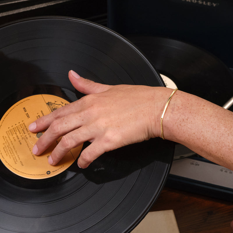 10kt yellow gold curb-link bar bracelet on wrist, round-ring clasp with flat bar