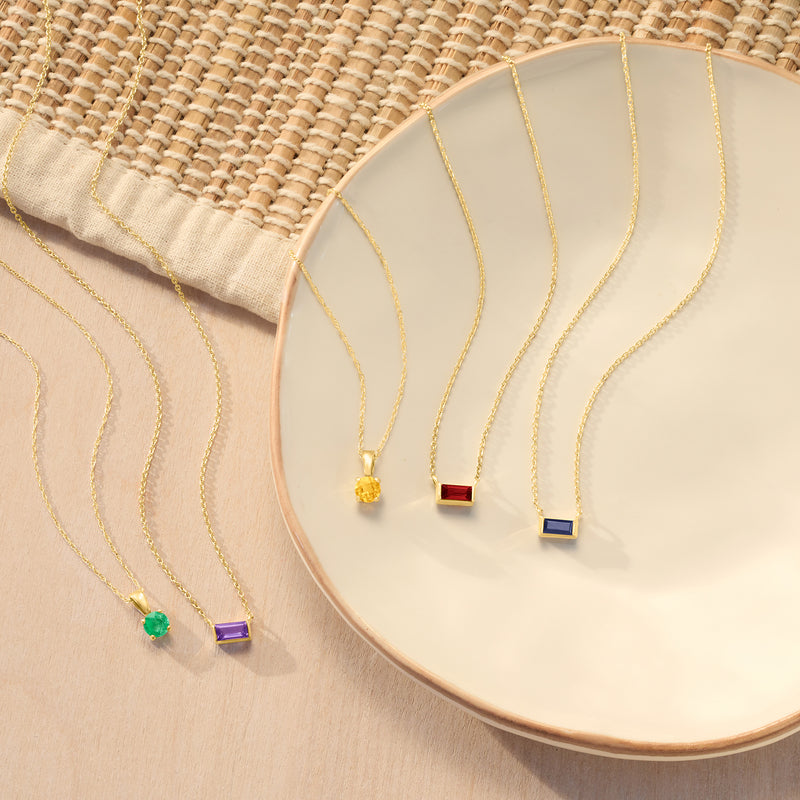 Emerald pendant necklace in yellow gold with small round green gemstone on chain