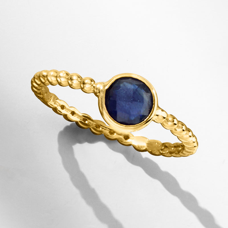 14kt yellow gold beaded sapphire ring with oval blue stone in scalloped bezel