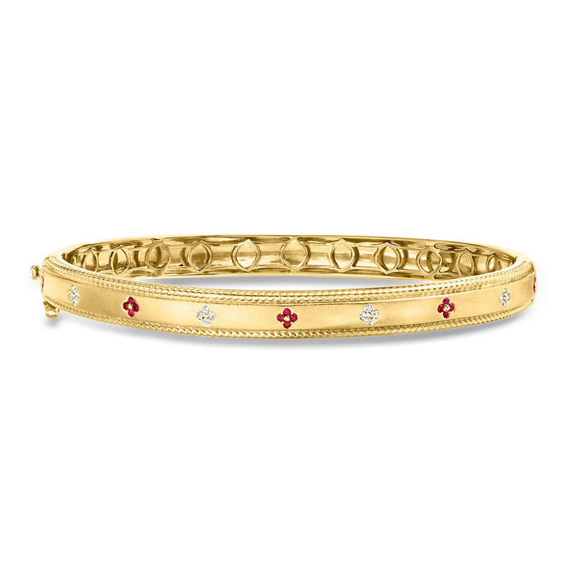 Gold over sterling bangle with red and blue flower charms and small sparkle stones.