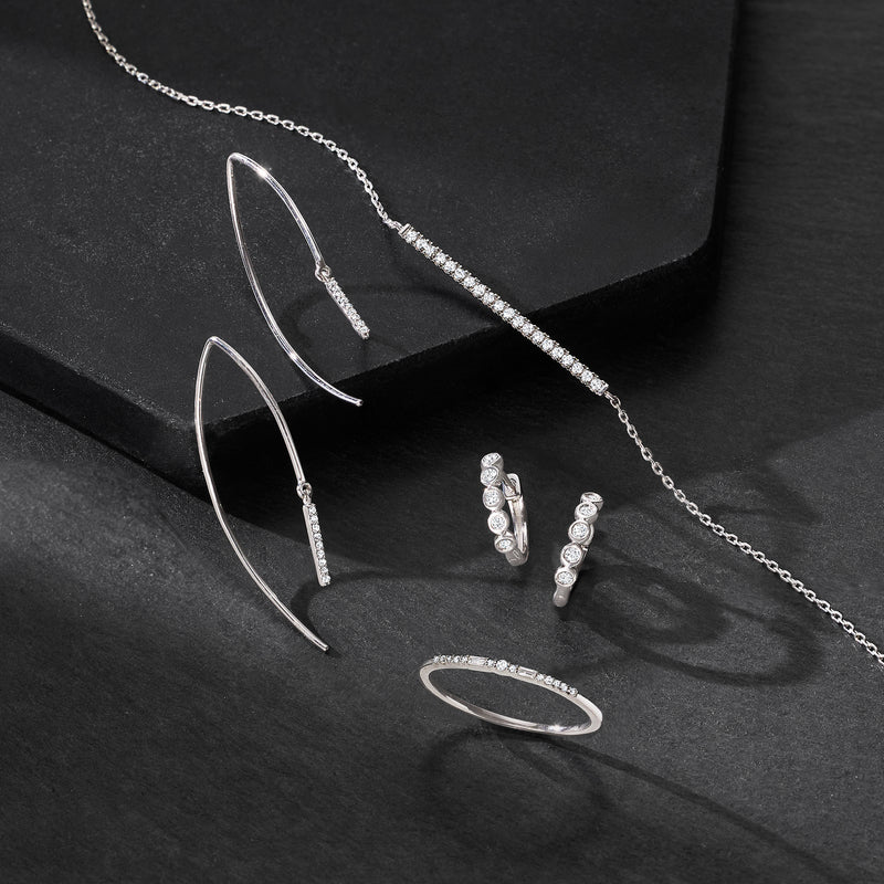 Set of silver hoop earrings with small round bezel-set stones on front