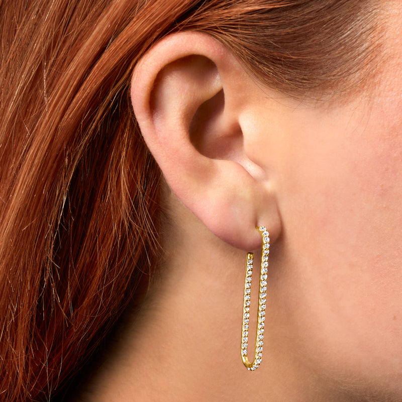 14kt yellow gold inside-out diamond hoop earring on ear, close-up