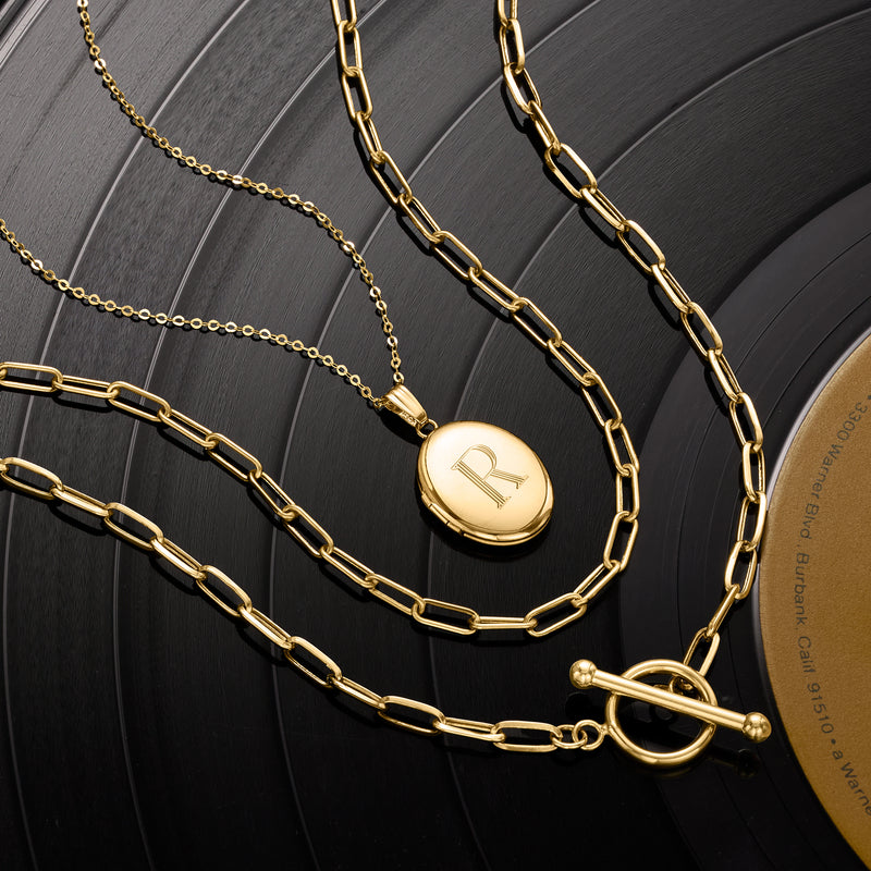 Yellow gold paper clip link necklace with round charm engraved 'R' and toggle clasp