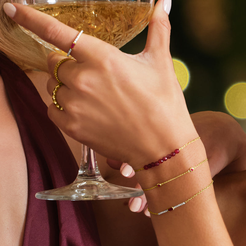 14kt yellow gold bracelet with small purple ruby stones along the chain