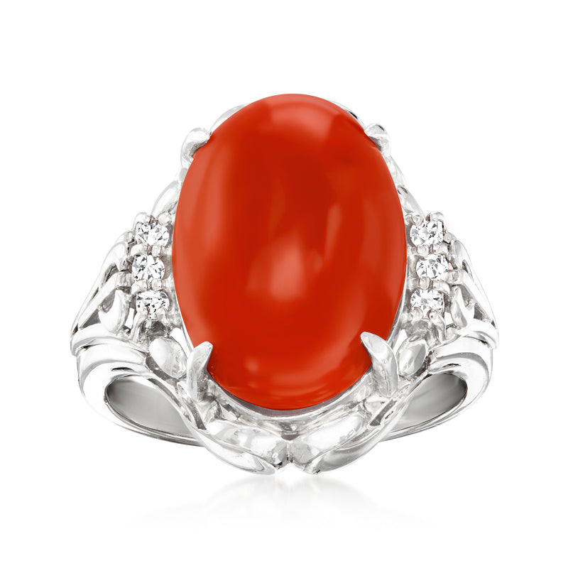 Platinum ring with oval red coral cabochon and diamond accents on the band