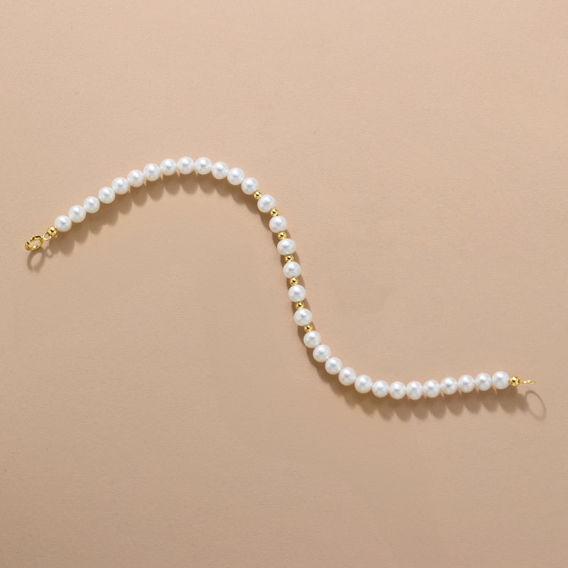 Cultured pearl bead bracelet close-up with white pearls and gold end clasp