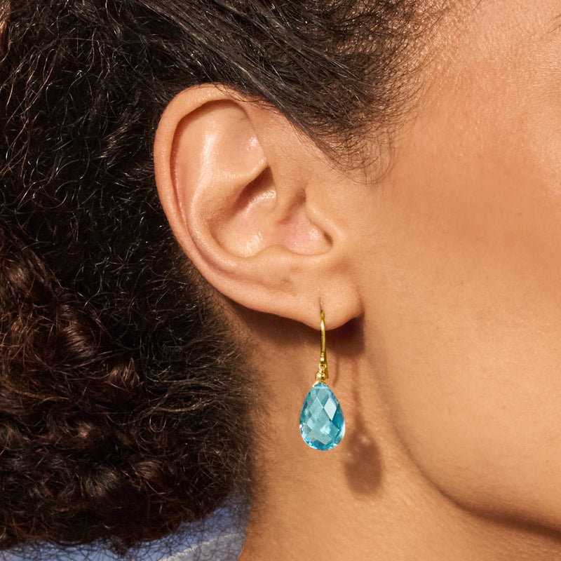 Sky blue teardrop gemstone drop earrings in 10kt yellow gold on earwires, close-up