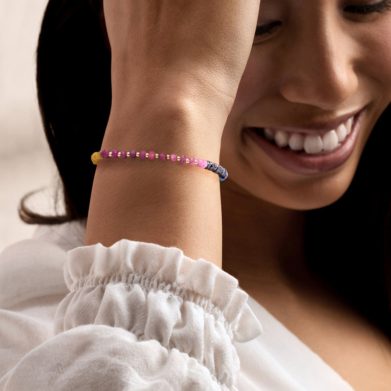 Multicolor gemstone bead bracelet on wrist with 10kt yellow gold clasp