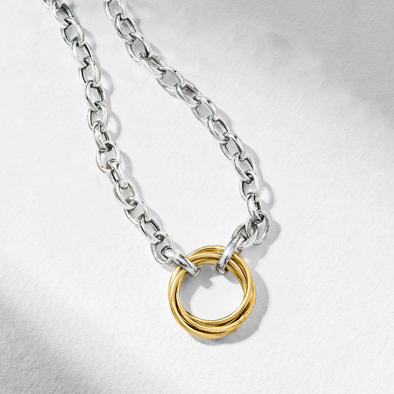Sterling silver rolo chain necklace with intertwined gold ring accents, close-up.