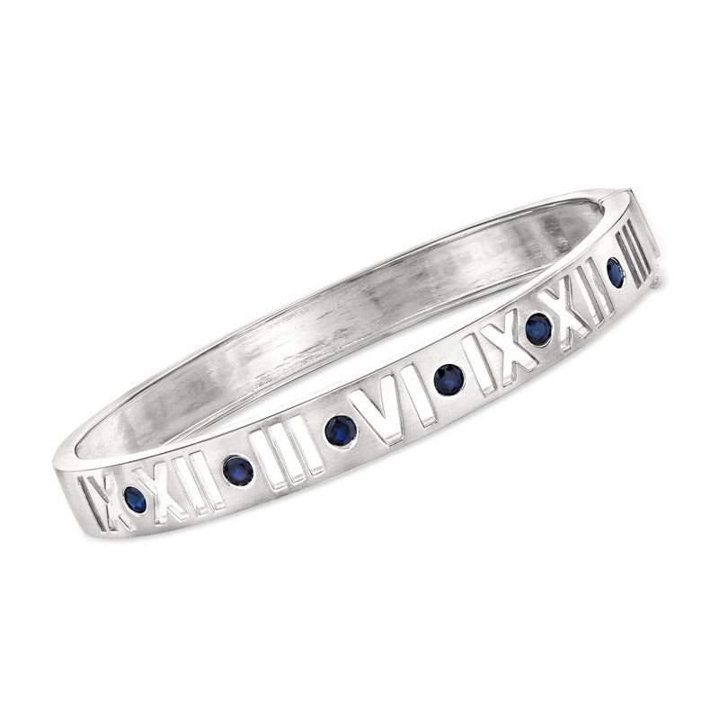 Sterling silver bangle bracelet with Roman numeral design and blue sapphire accents