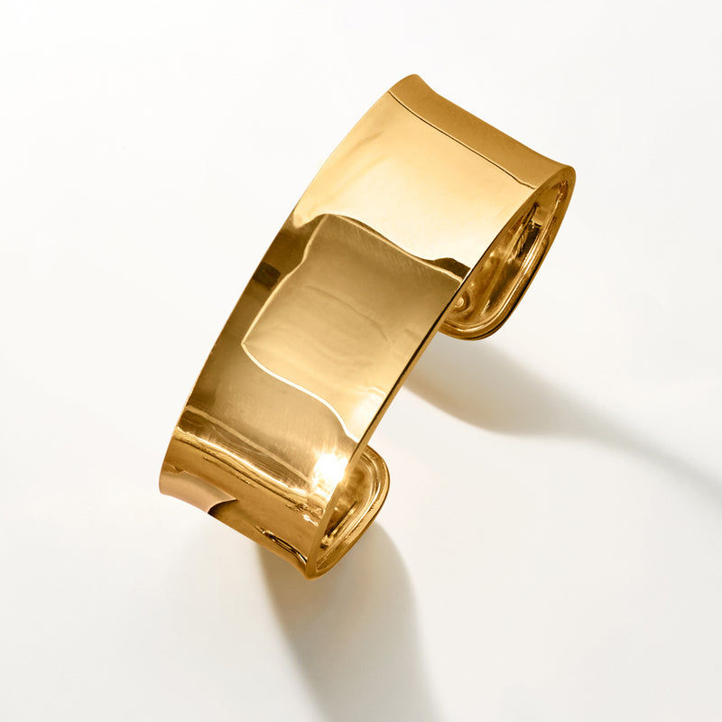 Wide polished gold cuff bracelet shown from the side with open hinge detail