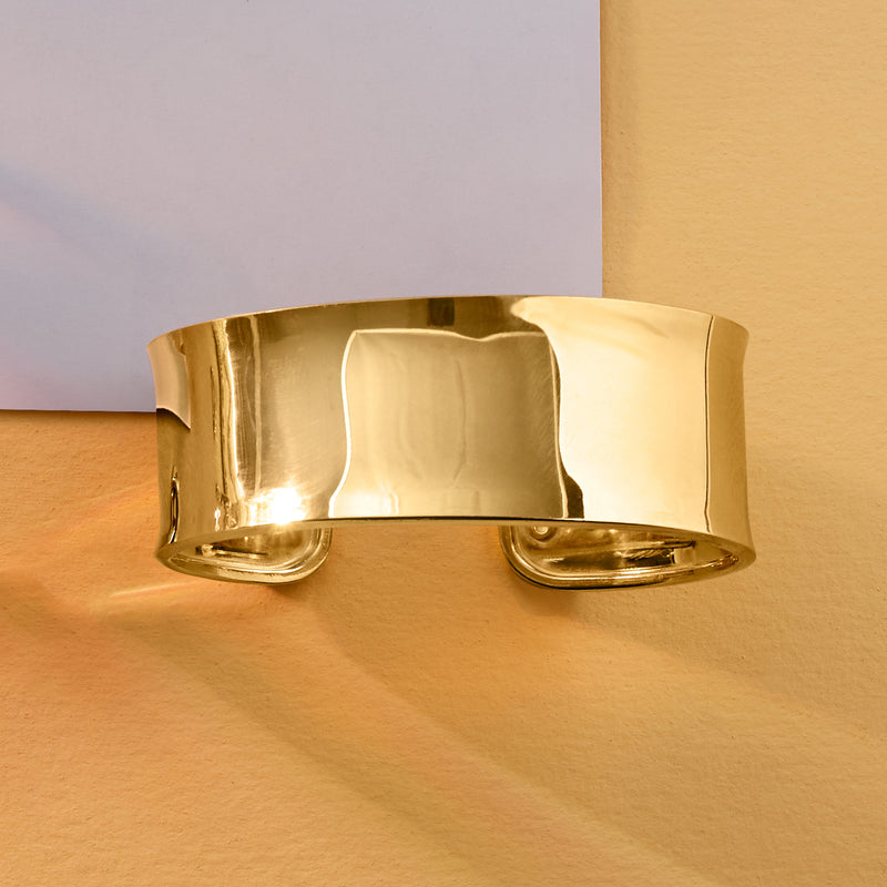 Polished gold cuff bracelet with rounded top and smooth shine, front view