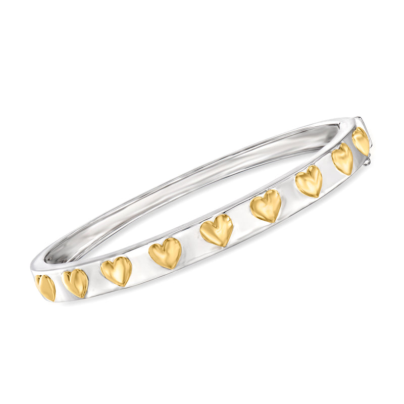 Two-tone bangle bracelet in sterling silver with raised heart charms along the cuff