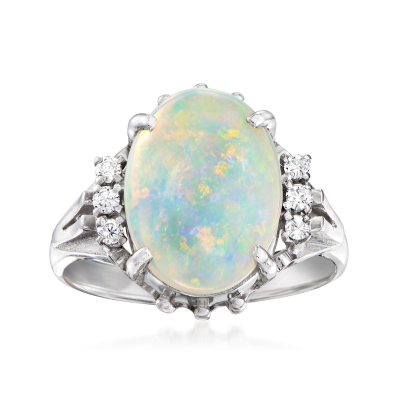Platinum ring with oval opal cabochon and side diamond clusters