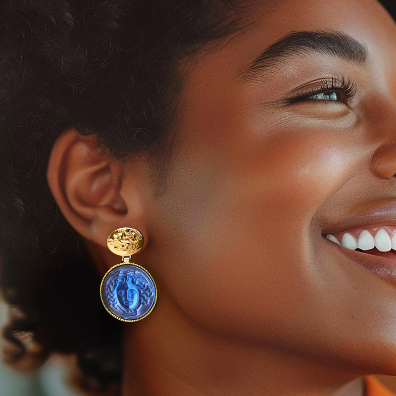 Gold-tone Medusa drop earrings with blue glass cameo on a model