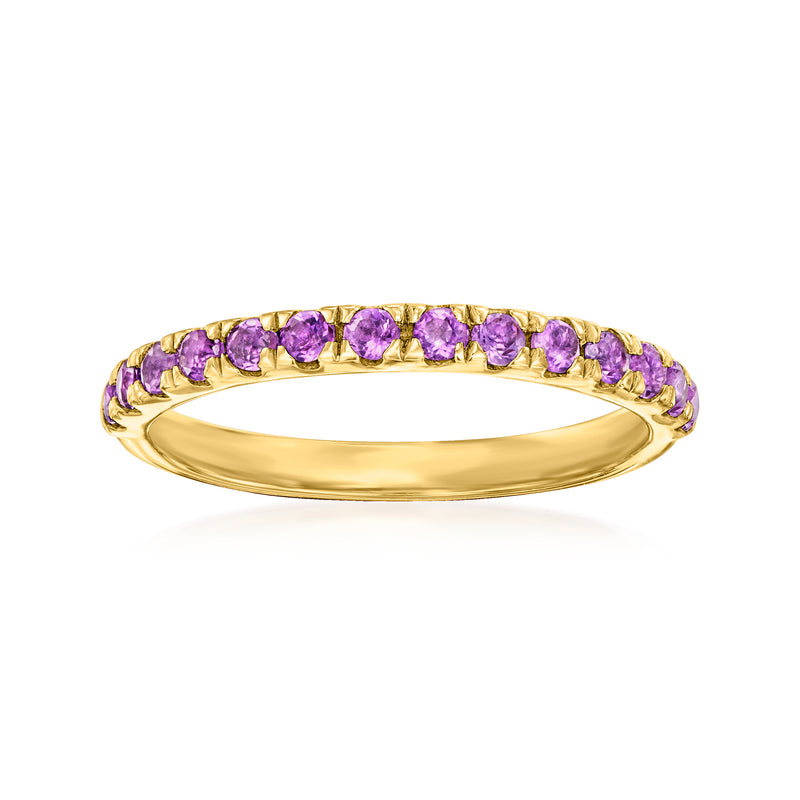 Gold ring with purple amethyst-like gemstones set in a full hoop with scalloped edges