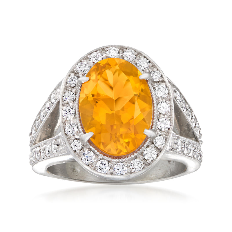 Platinum ring with oval orange citrine center and round diamond halo