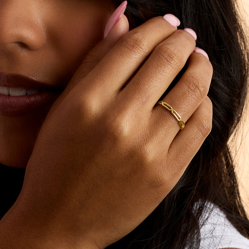 Yellow gold paper-clip link ring on finger with interlocking polished links