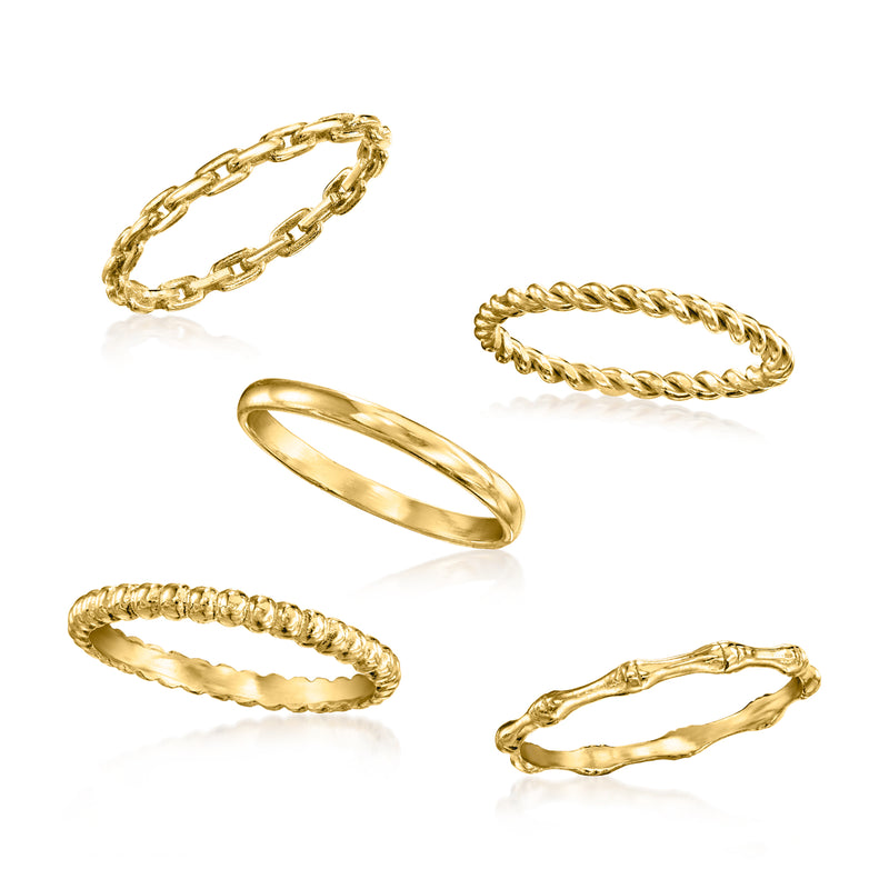 Stackable gold over sterling rings laid out flat: braided, chain-link, wavy and beaded