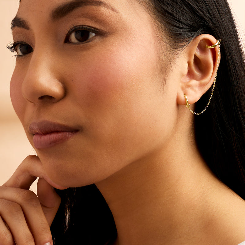 Yellow gold hoop earring with ear cuff detail on ear