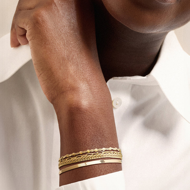 Gold-tone chain bracelets worn on wrist