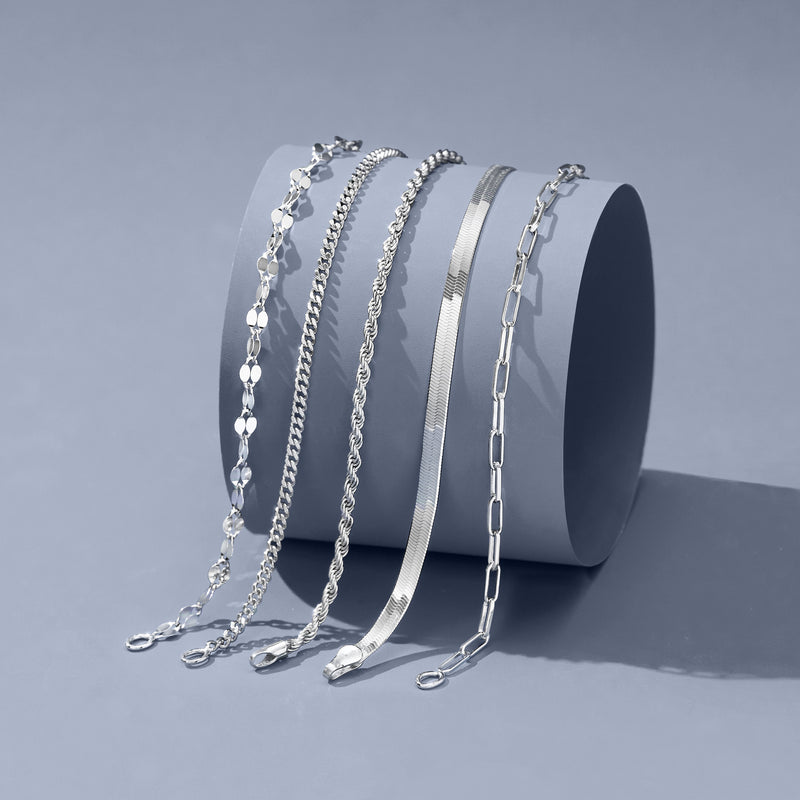 Five sterling silver chain bracelets shown together on a display base
