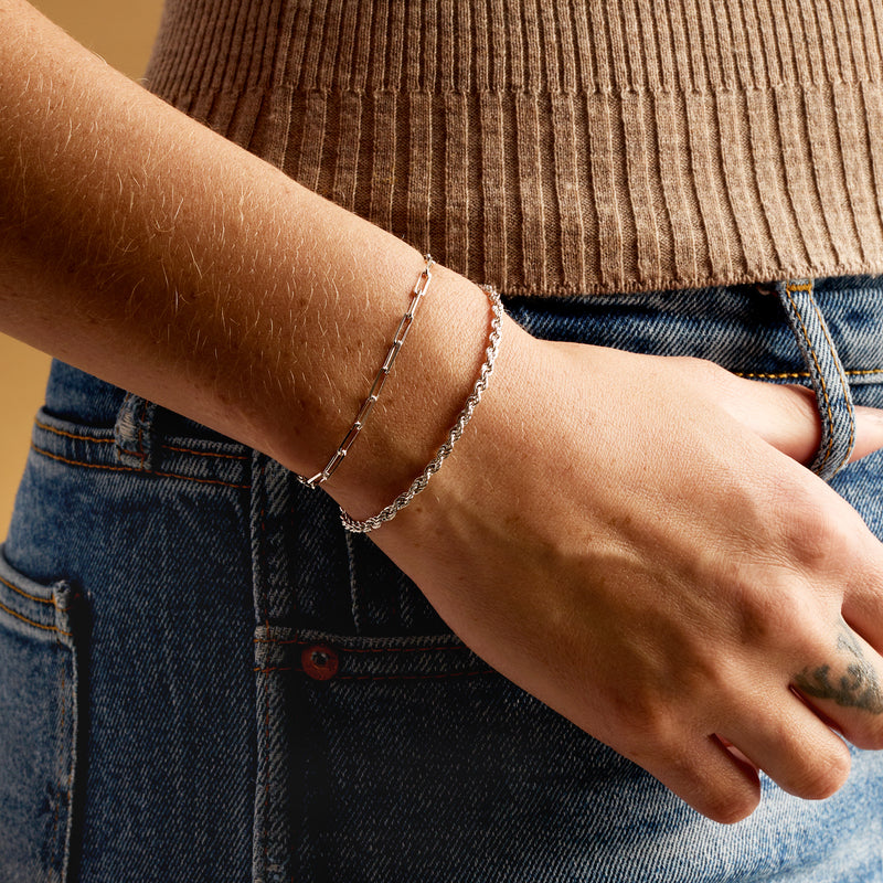 Sterling silver link bracelets on wrist with paper clip style chain