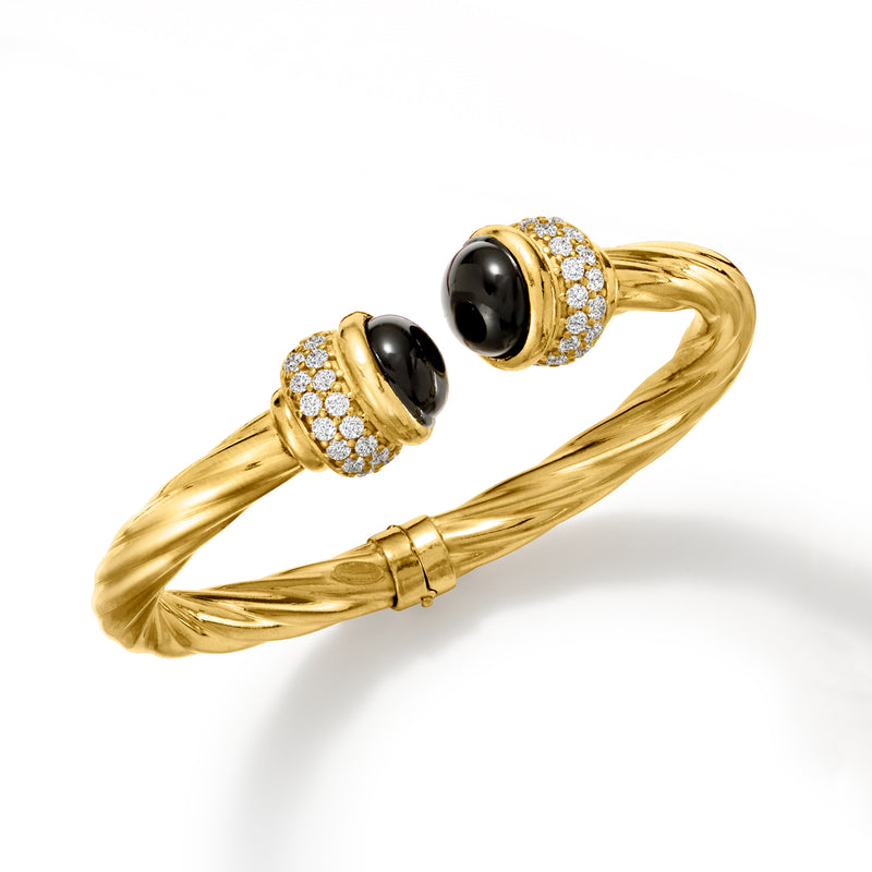 Twisted gold cuff bracelet with two black oval stones and sparkling CZ rings
