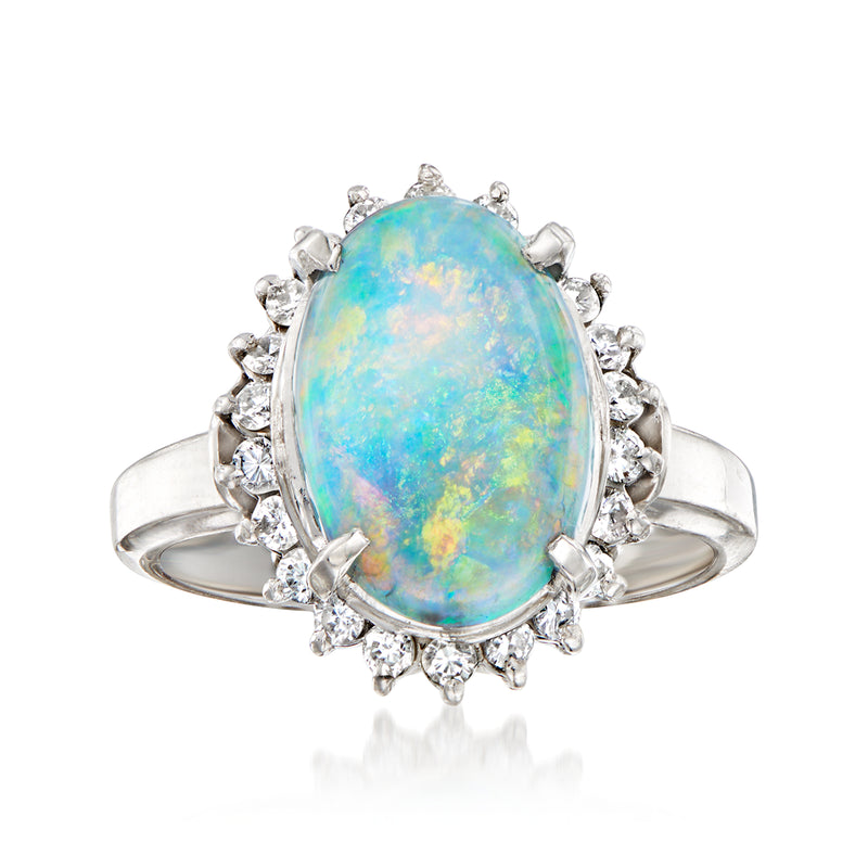 Platinum ring with oval opal center and diamond halo with raised prongs