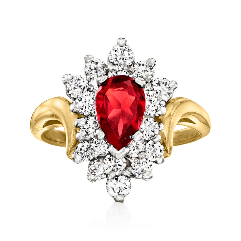 Two-tone gold ring with oval red garnet center and diamond cluster halo