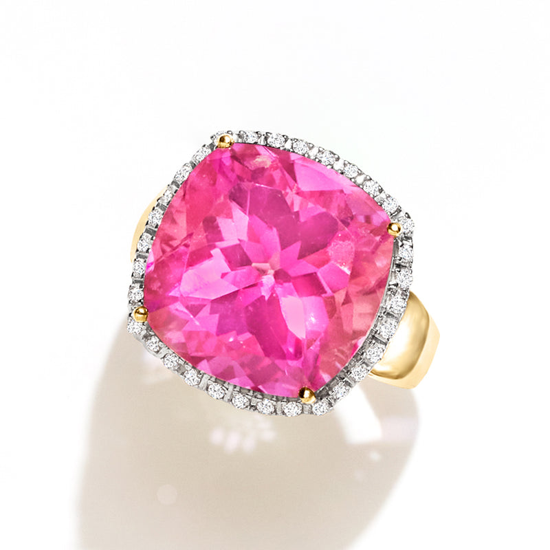 Oval pink topaz ring with diamond halo and gold prongs, angled view