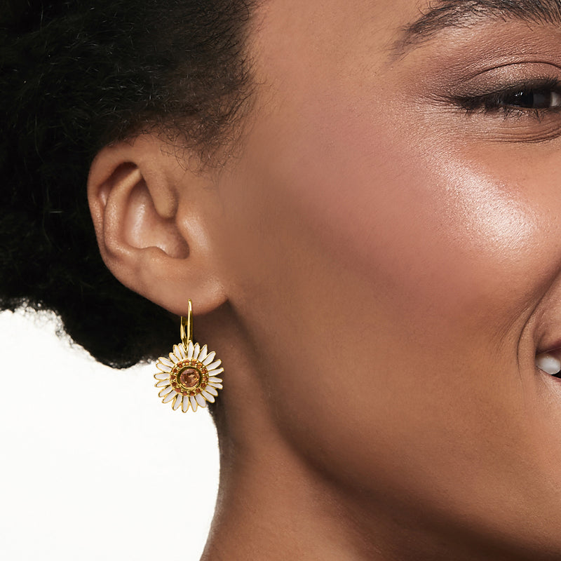 Wearing gold daisy drop earring with yellow citrine center and white enamel petals
