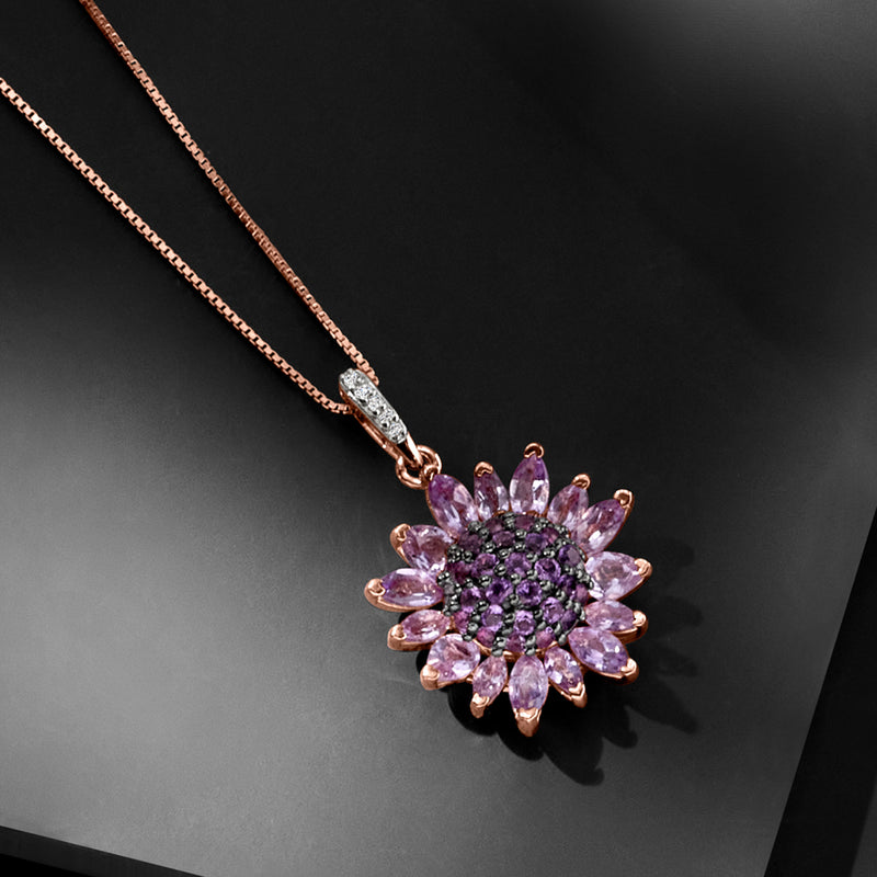 Rose gold amethyst flower pendant with sparkling clear accent stone at bail, angled view