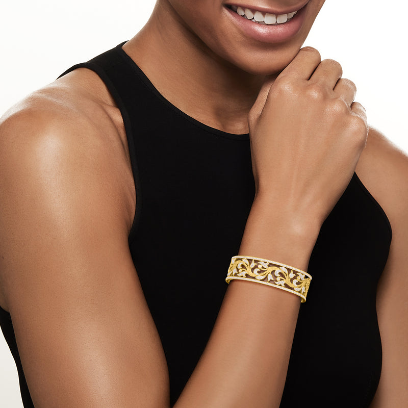 Diamond floral filigree cuff bracelet on wrist, gold tone with round stone accents