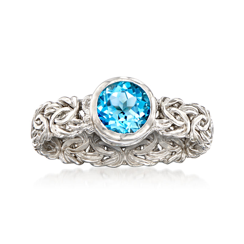 Sterling silver ring with bezel-set oval blue gemstone and Byzantine-style braided band