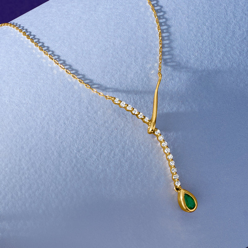 Yellow gold lariat necklace with diamond row and green teardrop emerald pendant