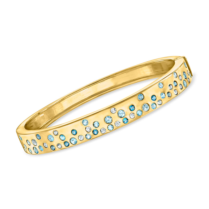 18kt gold bangle bracelet with blue and clear round stones in a row