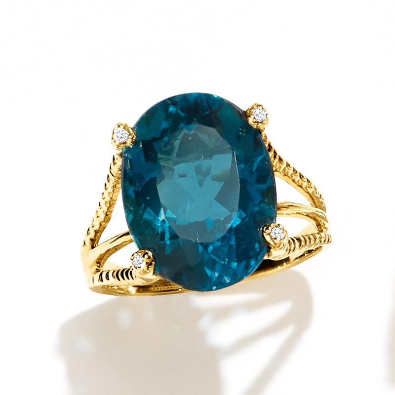 Teal-blue oval topaz ring with twisted gold shank and four small diamonds