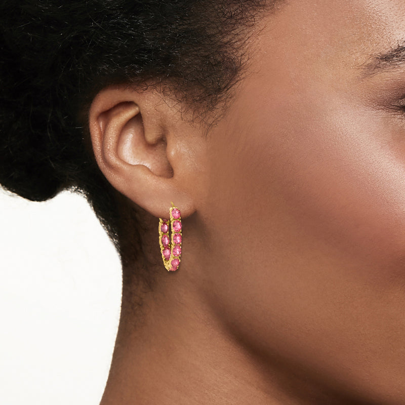 Pink gemstone hoop earrings on ear, gold-tone inside bezel setting