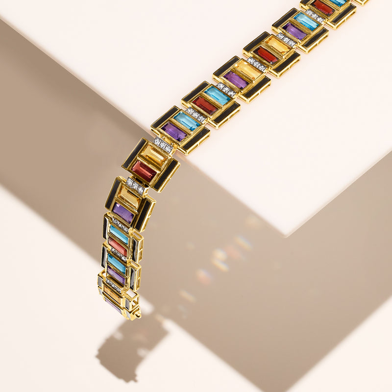 Gold-tone bracelet with multicolor gemstone squares and black enamel accents, close view
