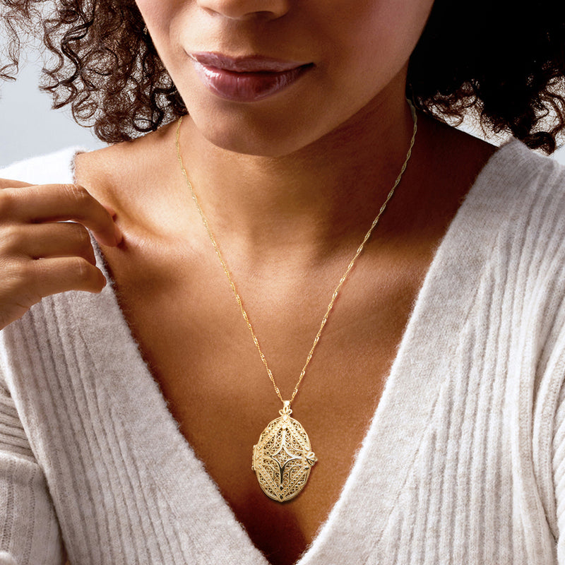 Gold locket pendant necklace on gold chain, worn on neckline